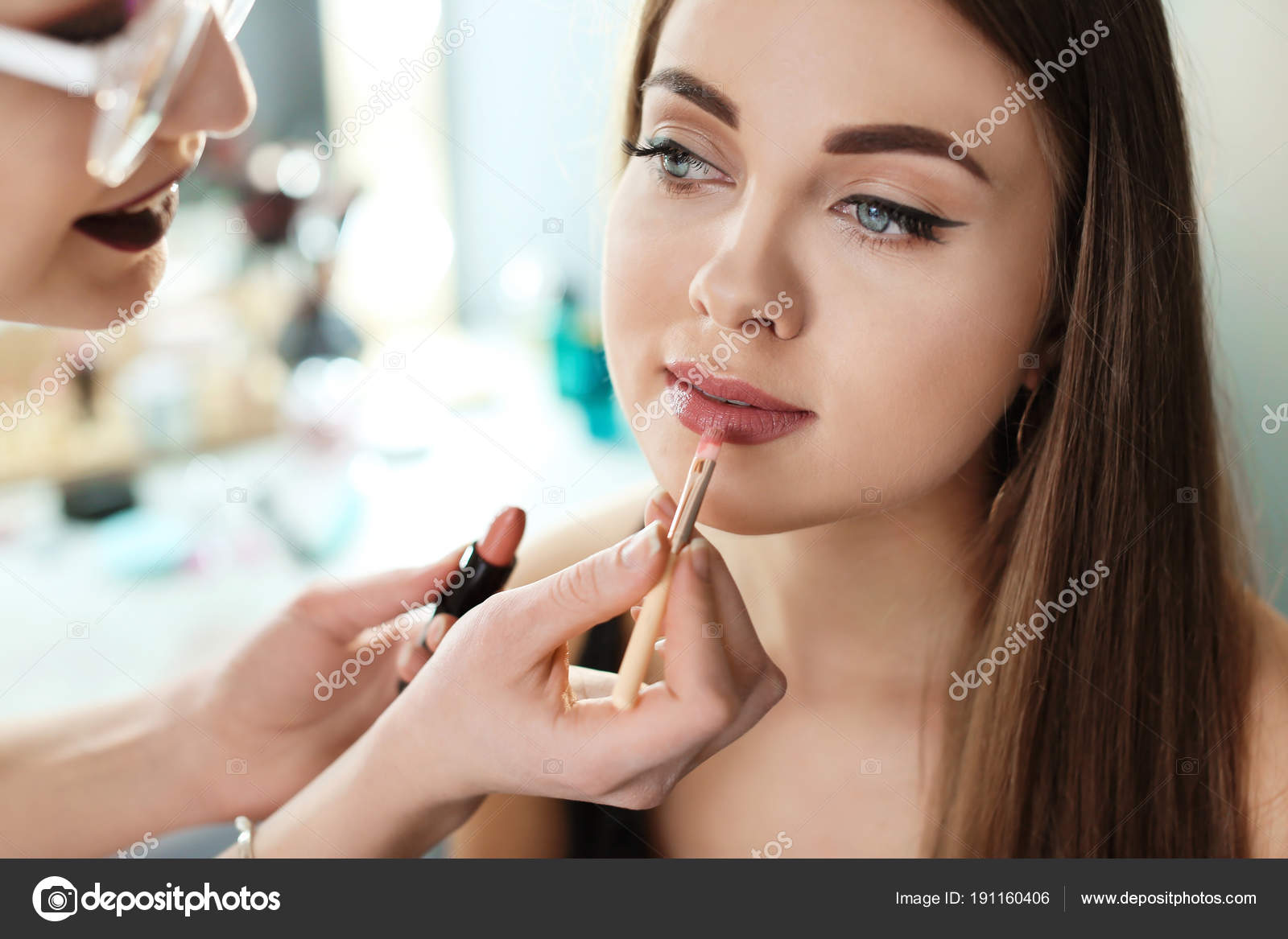 Professional Makeup Artist Working With Beautiful Young Woman In