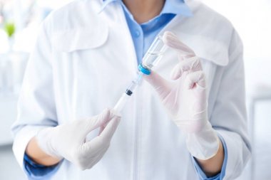 Şişe ve hastanede şırınga ile kadın doktor. Aşı günü
