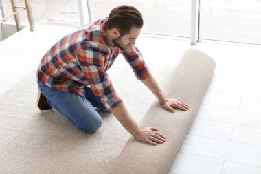 Oda içinde yeni halı döşeme yayıyoruz adam