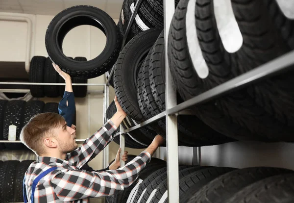 Jovens mecânicos masculinos com pneus de carro no centro de serviços de automóveis — Fotografia de Stock