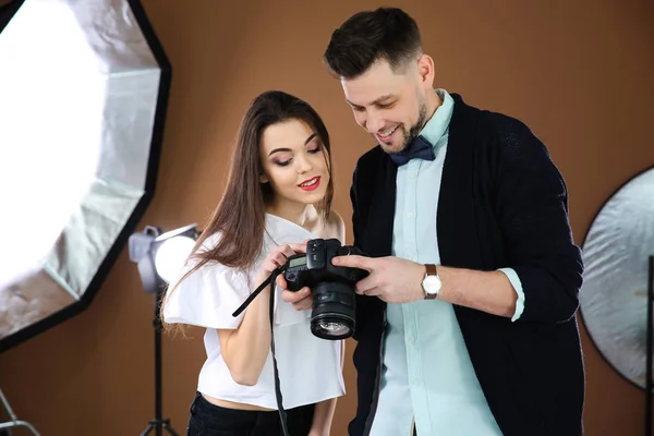 Modelo jovem bonito com fotógrafo profissional em estúdio — Fotografia de Stock