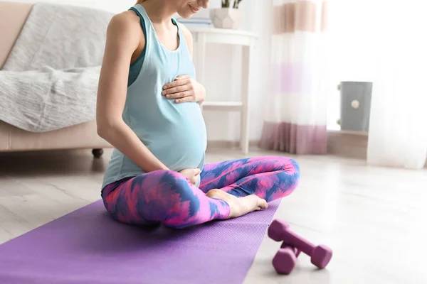 Νεαρή έγκυος γυναίκα κάνει ασκήσεις στο σπίτι — Φωτογραφία Αρχείου