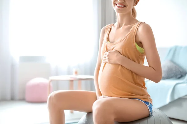 Giovane donna incinta che fa esercizi a casa — Foto Stock