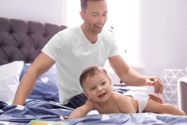 Mladý otec se synem roztomilý malý na posteli — Stock fotografie