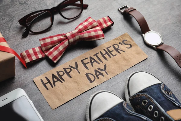 Kleine schoenen, verschillende gaven en kaart met woorden Happy Father'S Day op houten achtergrond — Stockfoto