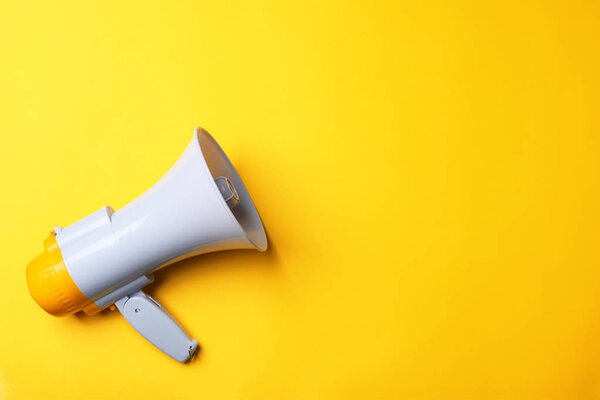 Electronic megaphone on color background