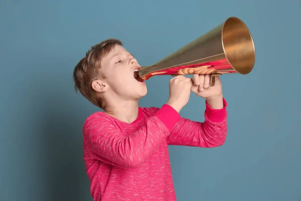 Милый маленький мальчик с мегафоном на цветном фоне — стоковое фото