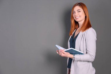 Gri arka plan üzerinde kitap ile güzel genç öğretmen