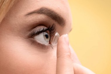 Genç kadın Kontakt lens gözüne renk arka planda, closeup koyarak.
