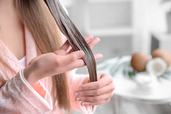 Junge Frau trägt zu Hause Maske auf Haare auf — Stockfoto