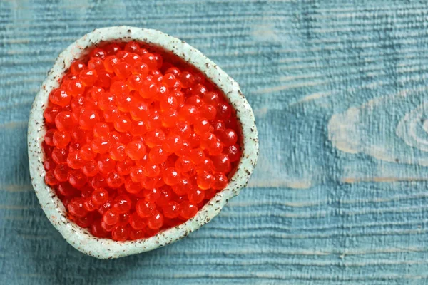 Cuenco de cerámica con delicioso caviar rojo en la mesa —  Fotos de Stock