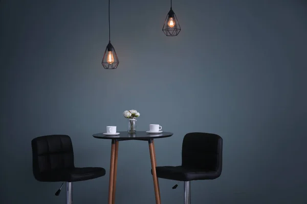 Stůl s židlemi tmavé zdi. Elegantní interiér — Stock fotografie