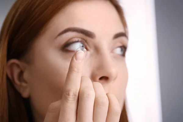 Mujer joven poniendo lentes de contacto en su ojo, primer plano —  Fotos de Stock