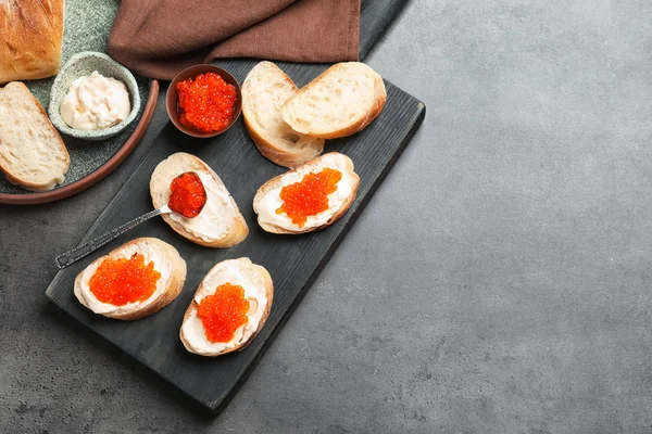 Heerlijke broodjes met rode kaviaar op houten bord — Stockfoto