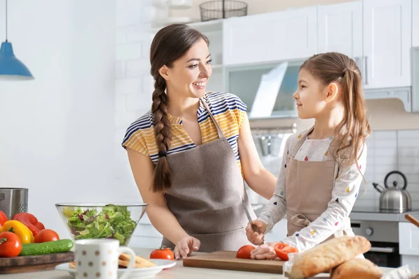Young nanny with cute little girl cooking together in kitchen — Stock Photo, Image