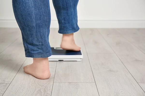 Mulher com excesso de peso usando escalas dentro de casa — Fotografia de Stock