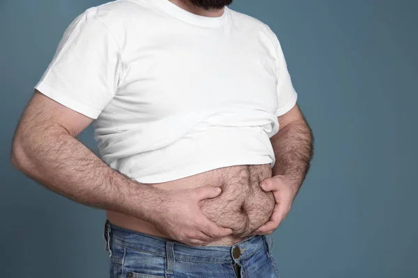 Overweight man on color background