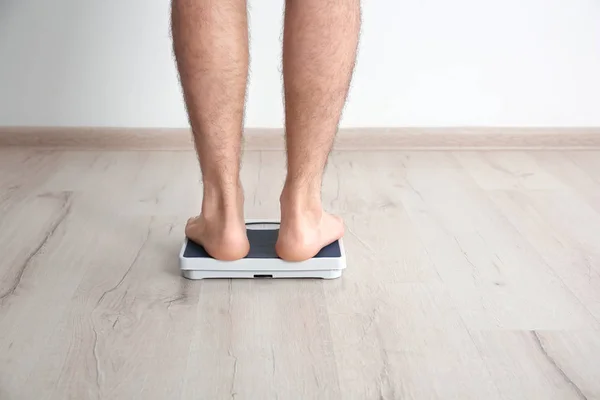 Homem com excesso de peso medindo seu peso dentro de casa — Fotografia de Stock
