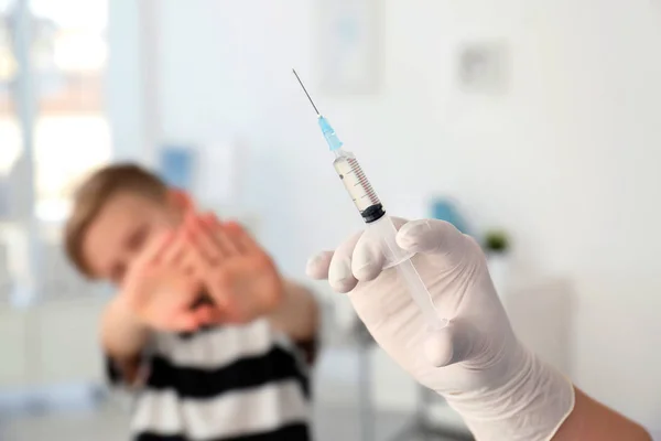 Médico con jeringa y niño sobre fondo. Día de vacunación —  Fotos de Stock