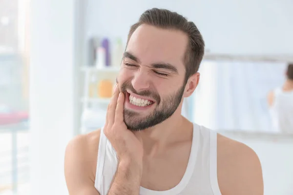 Young man suffering from toothache indoors — Stock Photo, Image