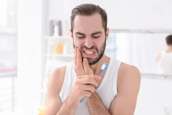 Young man suffering from toothache indoors — Stock Photo, Image