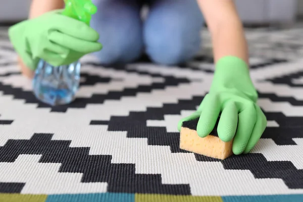 Woman cleaning carpet in living room — Stock Photo, Image