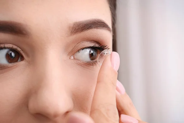 Mulher jovem colocando lente de contato em seu olho, close-up — Fotografia de Stock