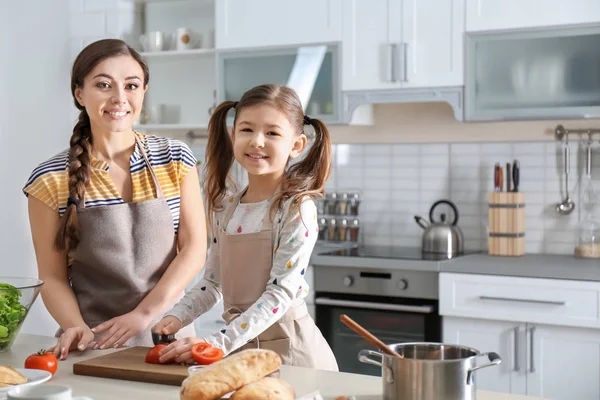 Jonge nanny met schattig klein meisje samen koken in de keuken — Stockfoto