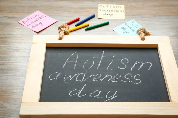 Schoolbord met zin "Autisme awareness day" op houten achtergrond — Stockfoto