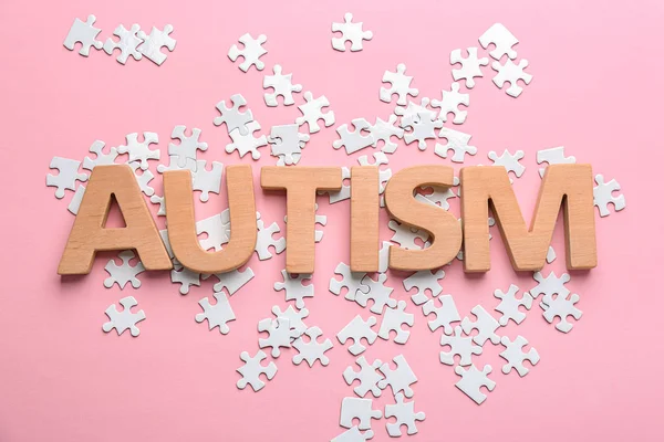 Word "Autisme" en puzzel stukjes op kleur achtergrond — Stockfoto