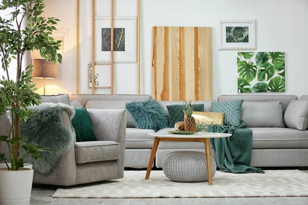 Стильный интерьер гостиной с удобным диваном и креслом — стоковое фото