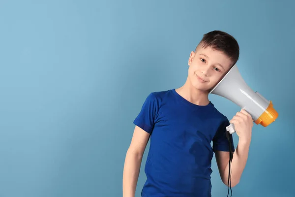 Милый маленький мальчик с мегафоном на цветном фоне — стоковое фото