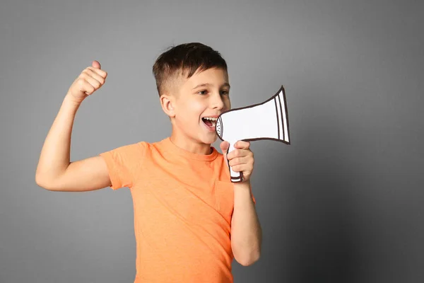 Schattige kleine jongen met papier megafoon op grijze achtergrond — Stockfoto