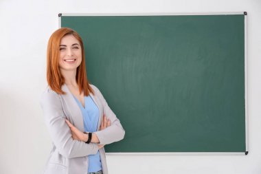 Yazı tahtası beyaz arka plan üzerinde yakın duran güzel genç öğretmen