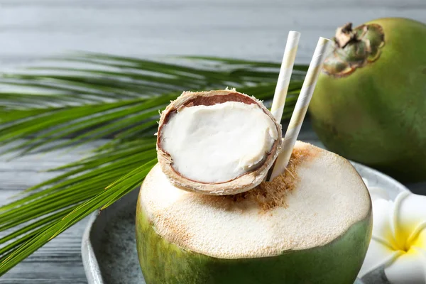 Verse groene kokosnoot met rietjes drinken op tafel, close-up — Stockfoto