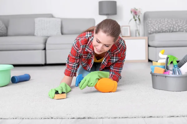 Kvinna rengöring mattan i vardagsrummet — Stockfoto