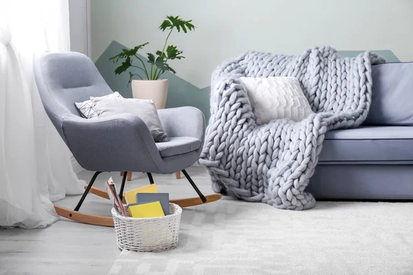 Стильный интерьер гостиной с удобным диваном и креслом-качалкой — стоковое фото
