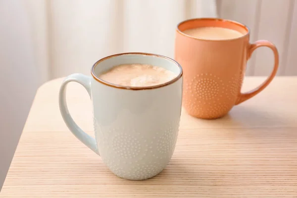 Copos de café quente aromático na mesa de madeira — Fotografia de Stock