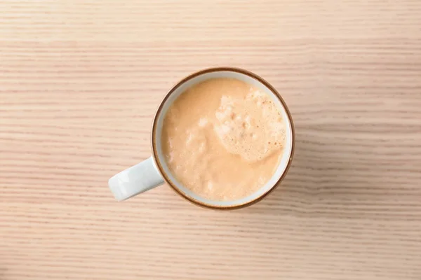 Taza de café caliente aromático sobre fondo de madera, vista superior — Foto de Stock