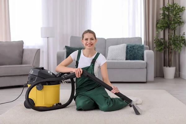 Női munkavállaló vákuum nappali szőnyeg takarítás — Stock Fotó