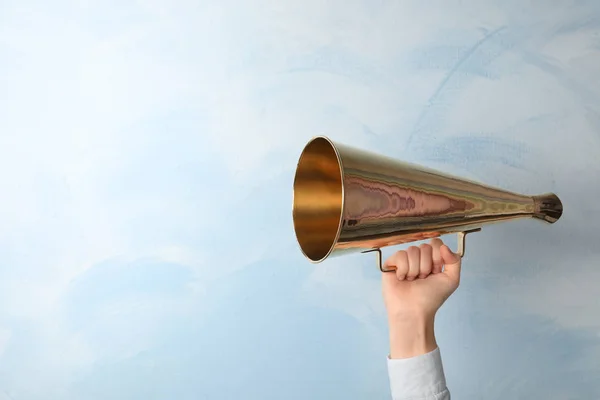 Woman holding retro megaphone on light background — Stock Photo, Image