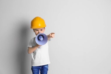 Kask üzerinde açık renkli megafon ile sevimli küçük çocuk