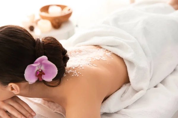 Beautiful young woman with body scrub on her back in spa salon — Stock Photo, Image