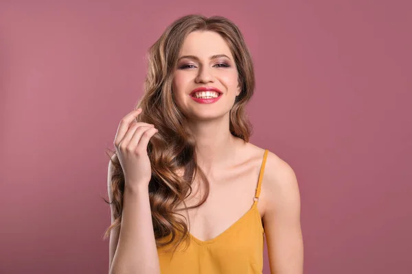 Porträt einer jungen Frau mit langen schönen Haaren auf farbigem Hintergrund — Stockfoto