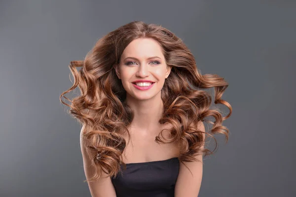Portré, fiatal nő, hosszú szép haj, a szürke háttér — Stock Fotó