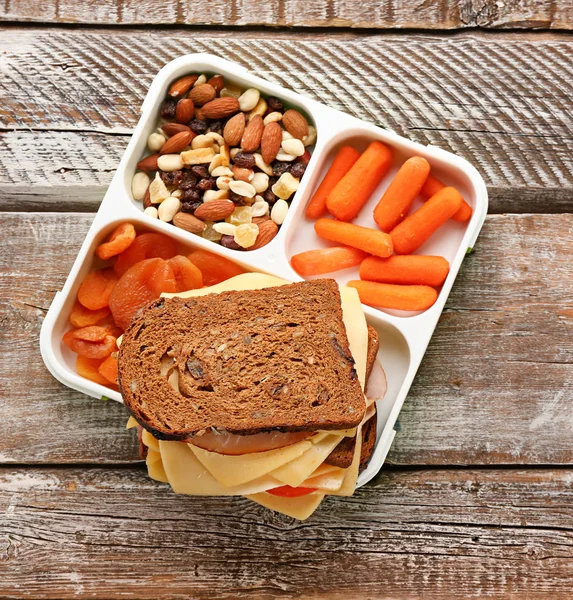Scatola da pranzo con cibo gustoso su sfondo di legno — Foto Stock