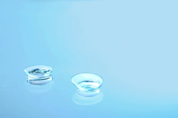 Lentes de contato no fundo de vidro — Fotografia de Stock