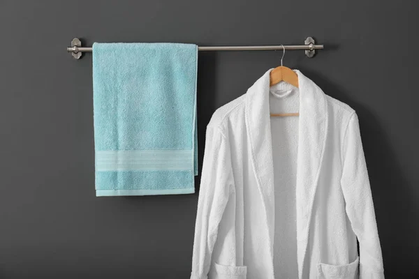 Percha con toalla limpia y albornoz en pared gris — Foto de Stock
