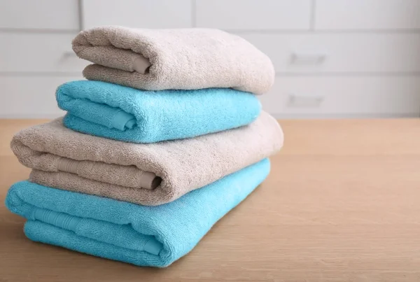 Stack of clean towels on table indoors — Stock Photo, Image
