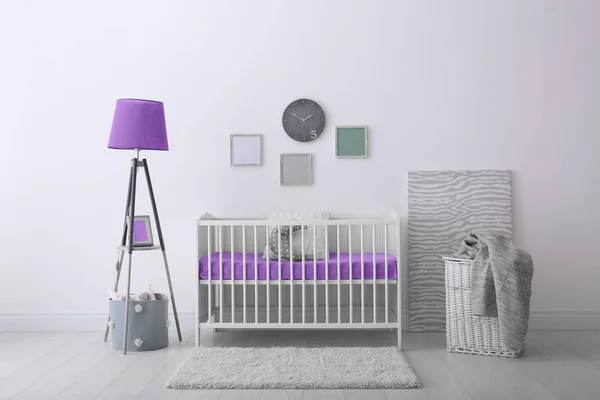 Baby room interior with crib near wall — Stock Photo, Image